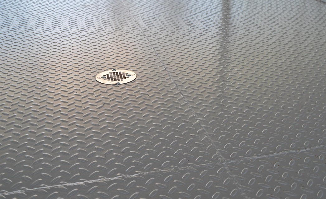 Draining floor for a shipping container water treatment plant