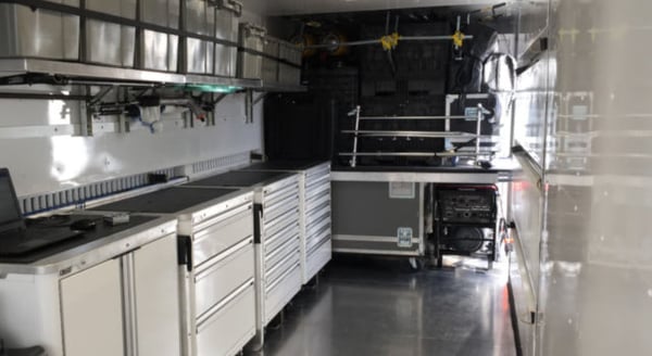 Interior of shipping container modified into a mobile car garage.