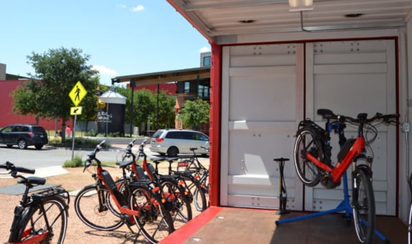 Interior of container-based store front which doubles as secure storage for e-bike fleet.