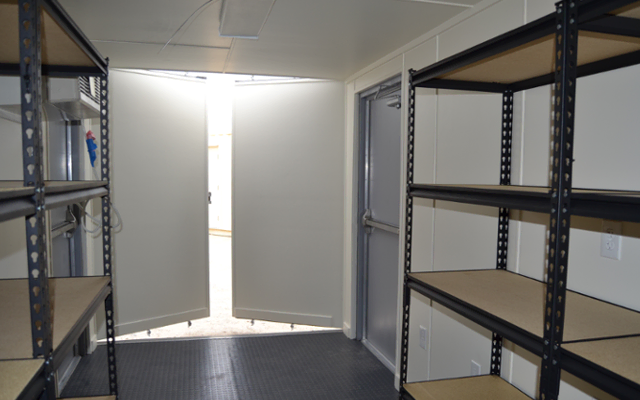 Interior of onsite ISO storage container with shelving. Interior of onsite ISO storage container with shelving.