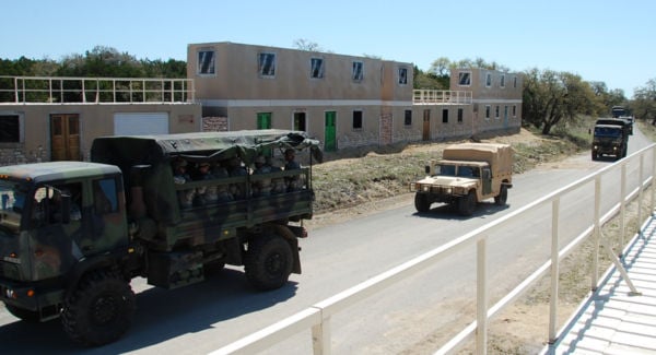 Trucks drive through conex container-based training village. Trucks drive through conex container-based training village.