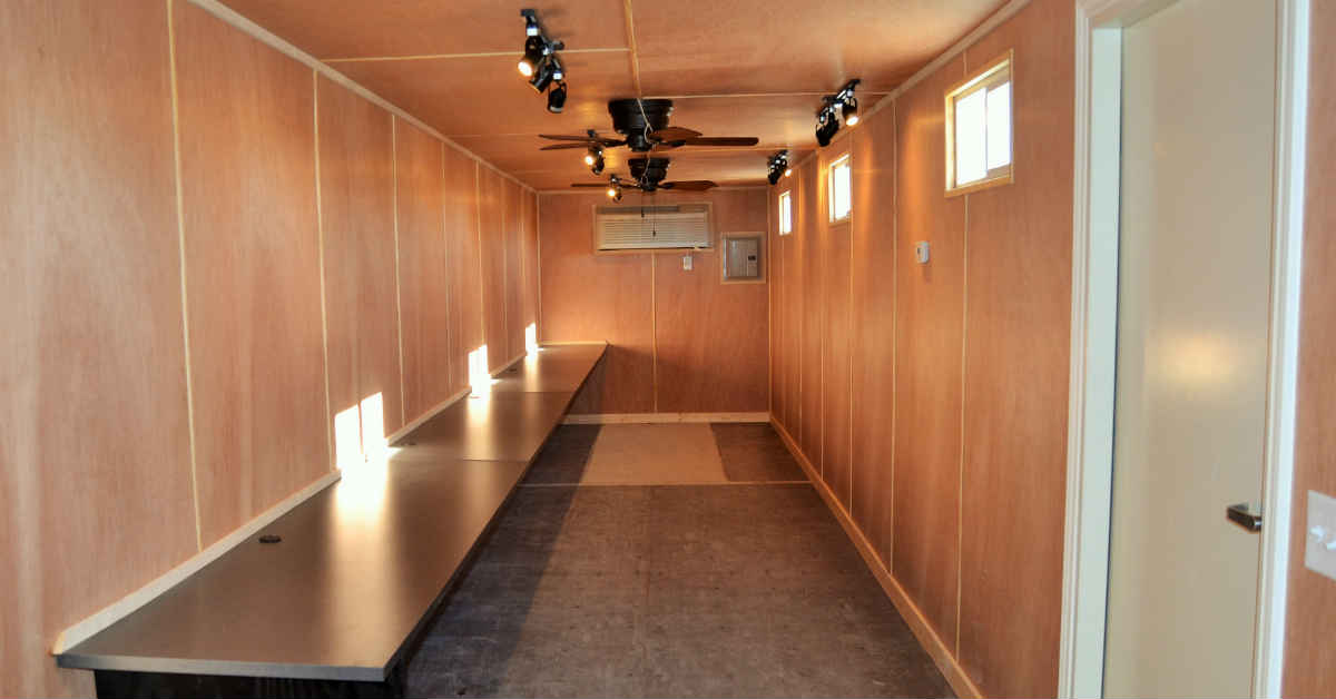 Interior of a portable sales office finished with wood paneling and desks. Interior of a portable sales office finished with wood paneling and desks.