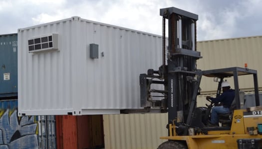 Shipping container being moved by forklift