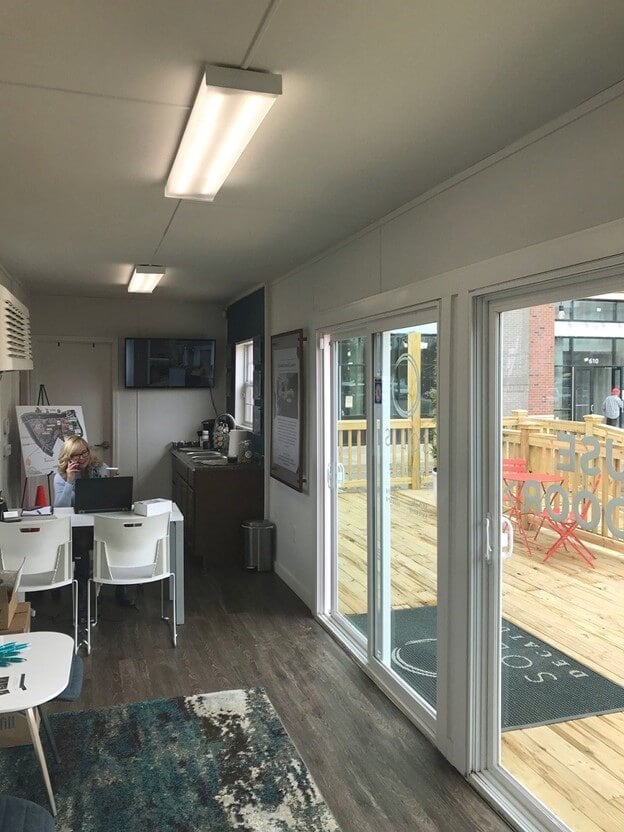 Interior of a shipping container office with sanded wood panel walls.