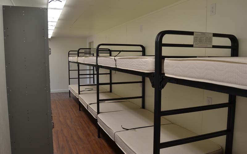 Interior of shipping containers modified into military barracks with bunks