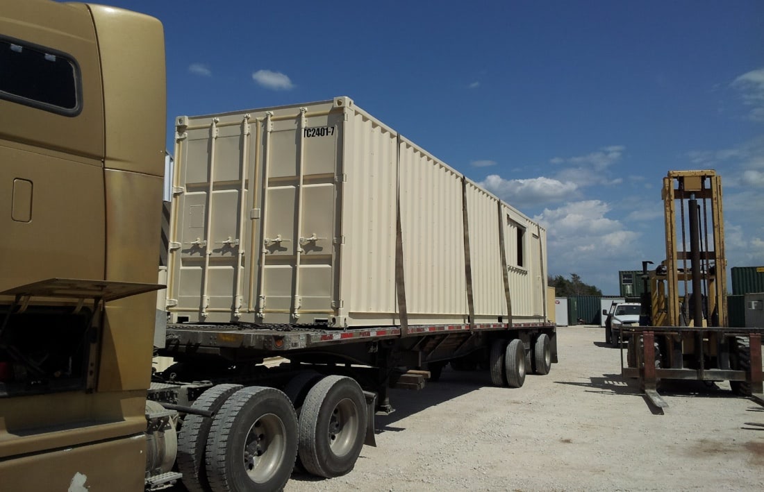 Delivery of modified shipping container on flatbed truck