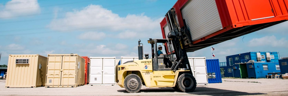 Forklift moving ISO shipping container for delivery