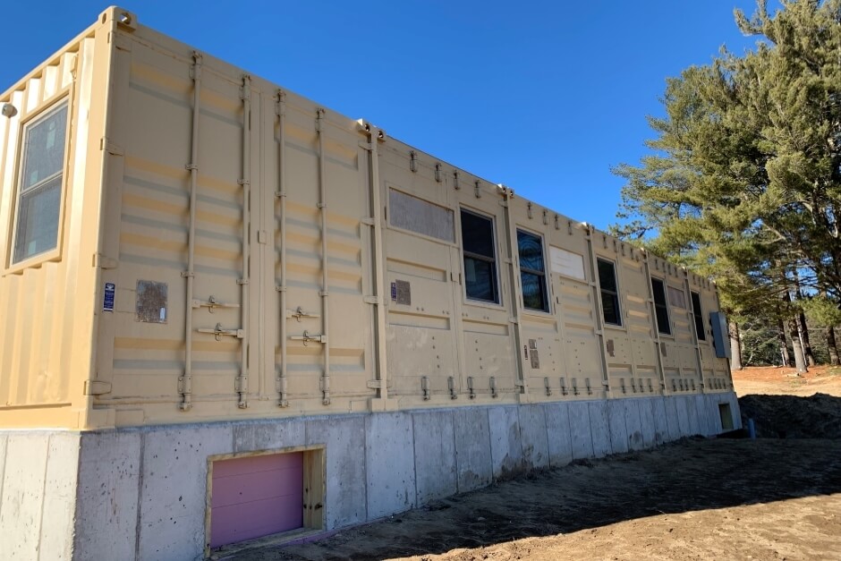 modified shipping container on foundation with six windows