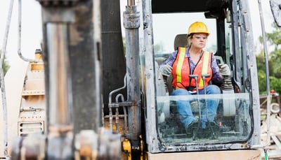 woman operating an earth mover on a construction site