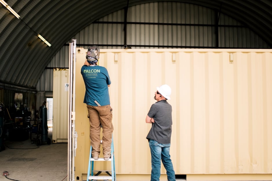 two men looking at a shipping container