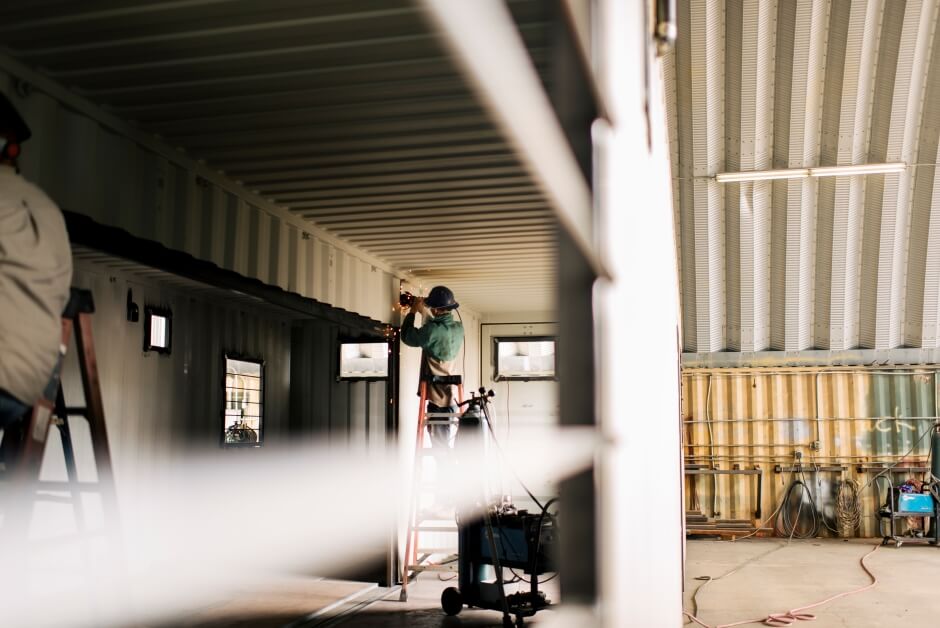 man grinding a modified shipping container