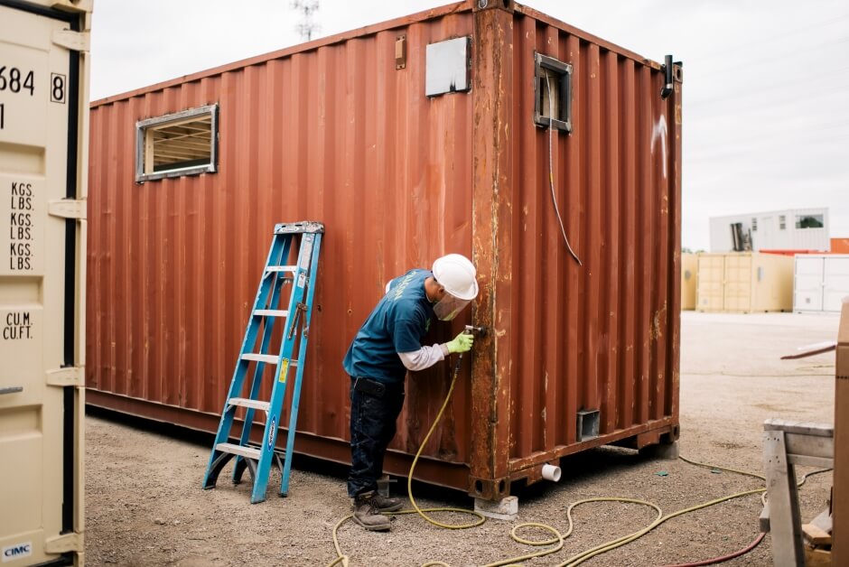 sanding down a shipping container