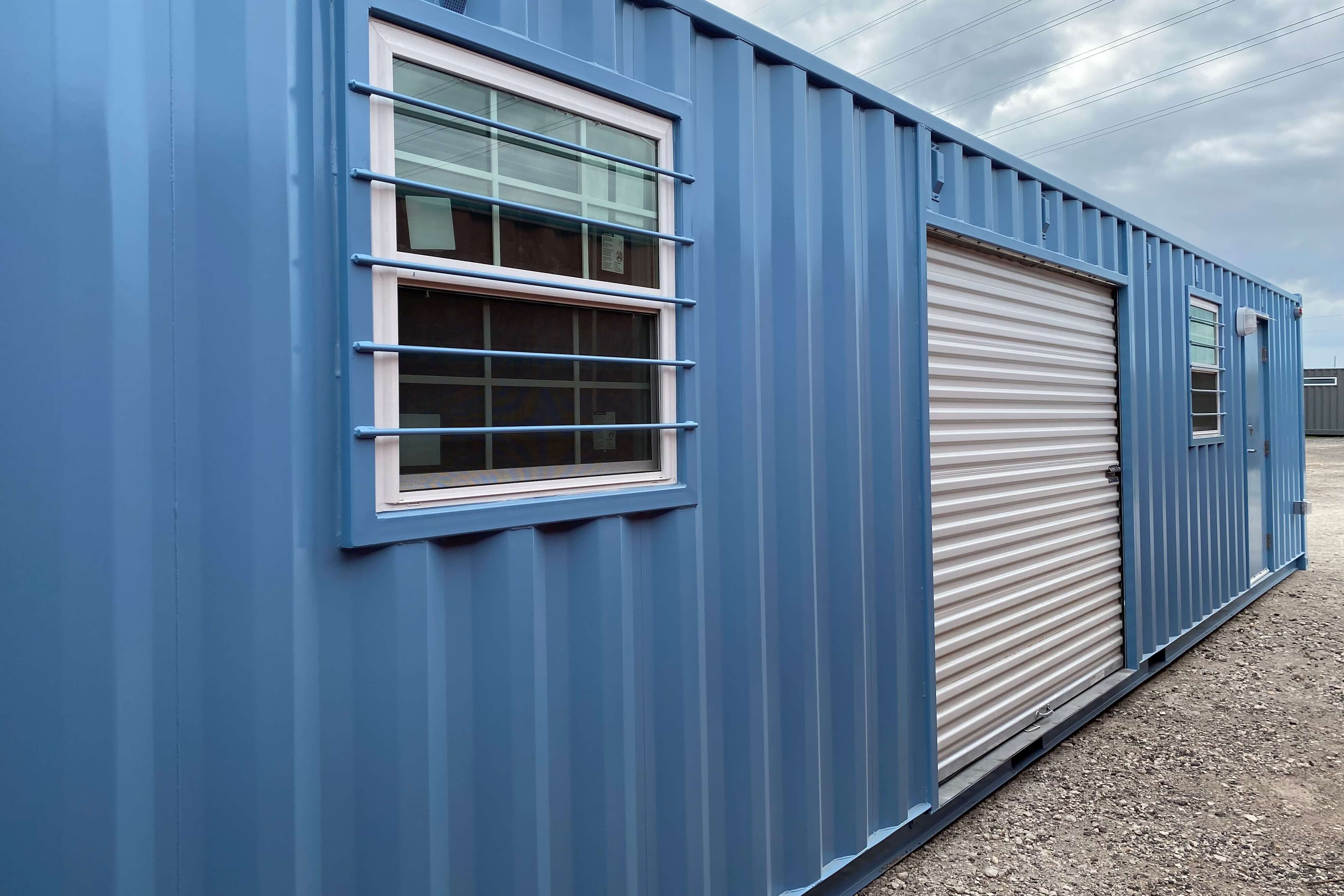 shipping container office with a roll up door and burglar bar windows
