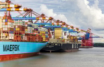 cargo ships carrying hundreds of shipping containers docked at port