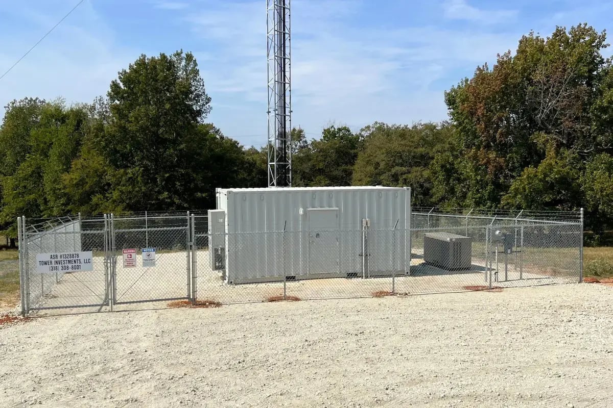 20ft equipment enclosure container on site underneath cell tower