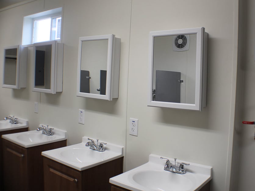 four sinks and mirrors in a shipping container bathroom