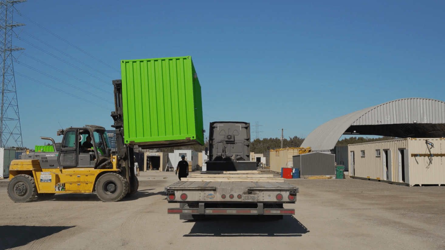 Delivery driver directing container onto shipping truck