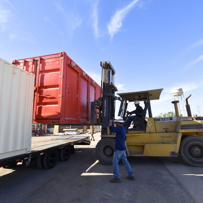 20ft container being set on truck flatbed for delivery