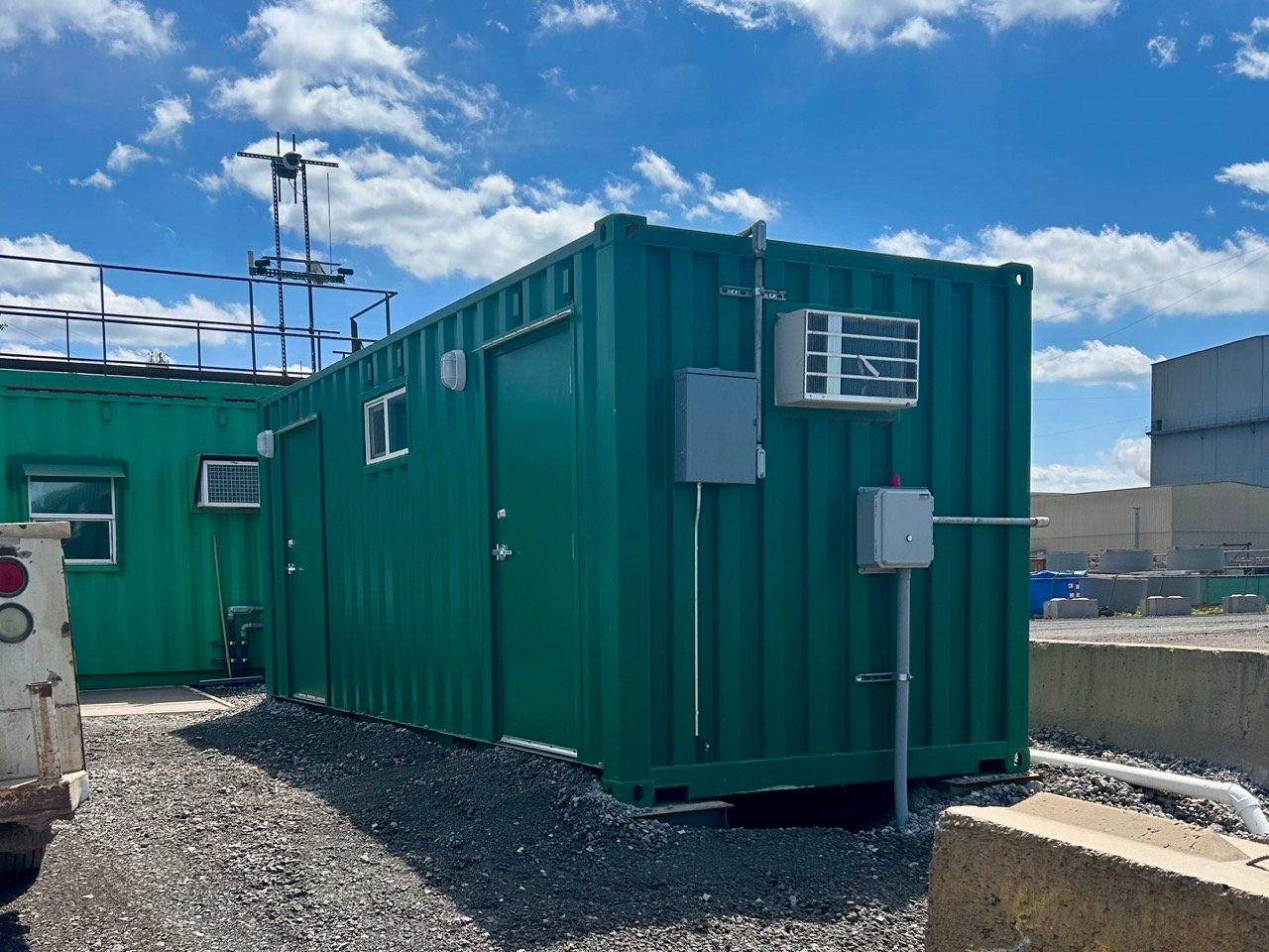 Container bathroom onsite with modified containers in background