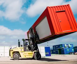 Red shipping container on forklift