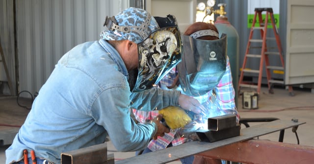 Adrian helps new boxpert, Paige, learn the basics of welding.