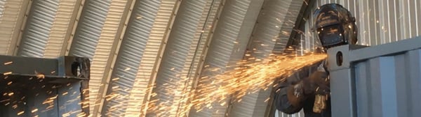 Falcon employee modifying a shipping container inside Falcon Structures' manufacturing facility.