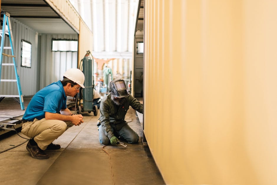 modified shipping container office with green stripe and rent vs. buy text