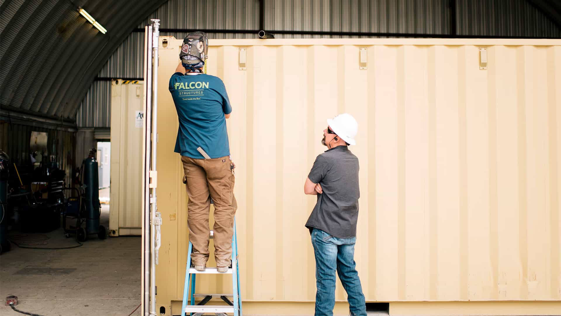 two-people-working-on-a-shipping-container