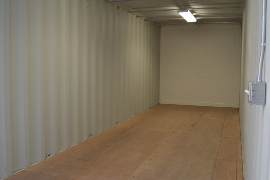 workers adding frames to the inside of a modified shipping container