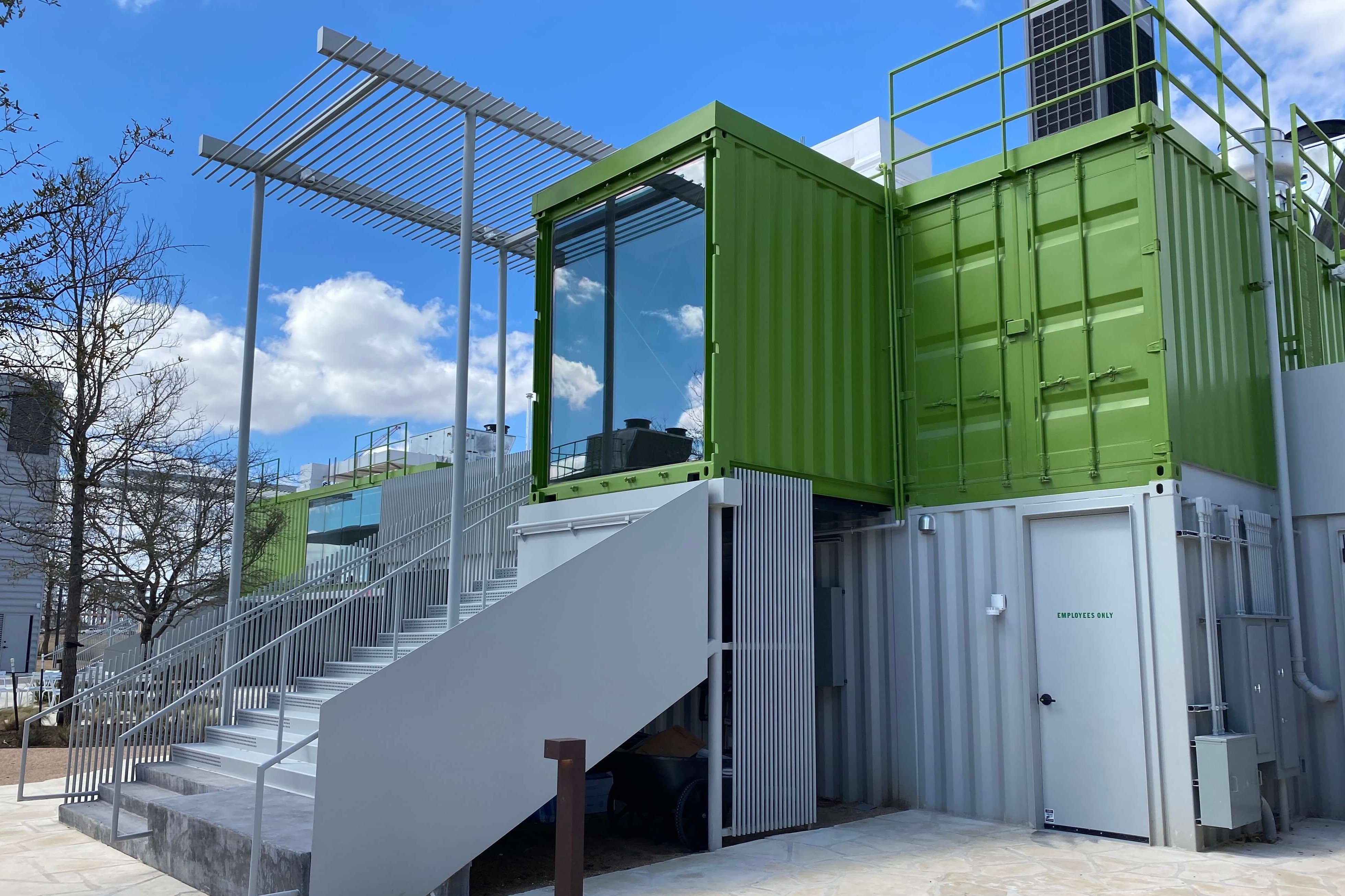 two men looking at a modified shipping container in production