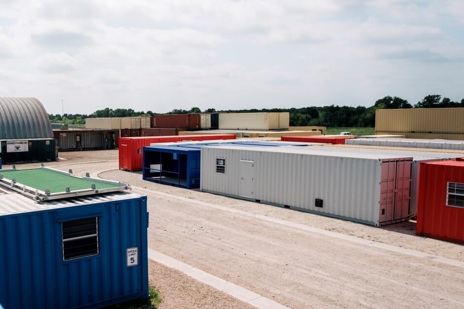 A high-cube shipping container next to a standard shipping container