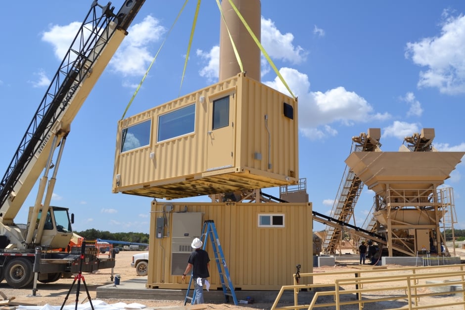 workers adding frames to the inside of a modified shipping container